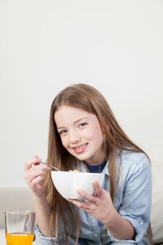Little girl eating cereal in the breakfast