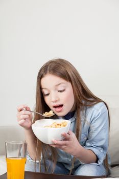 Little girl eating cereal in the breakfast