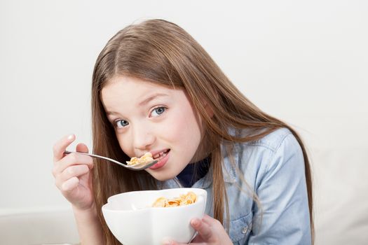 Little girl eating cereal in the breakfast
