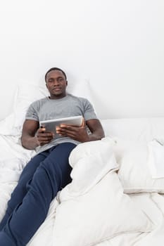 Man looking at camera and holding his tablet