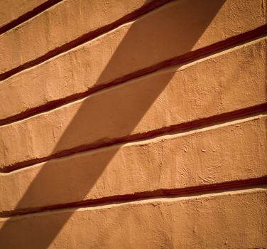 background or texture old orange wall with relief in the shade