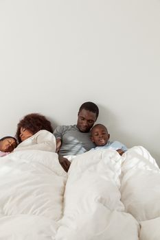 African family sleeping in the bed togehter