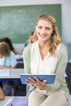 Portrait of female teacher using digital tablet in her class