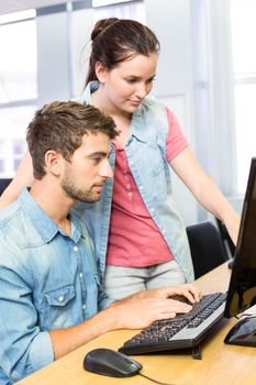 Computer teacher helping pretty female student in his class