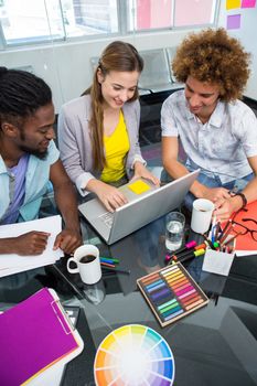 Creative young business people using laptop at office desk