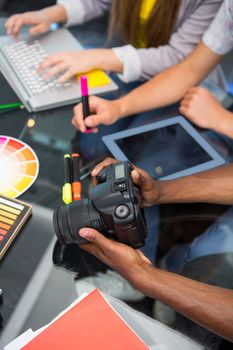 Close up of creative business people with digital camera at office desk