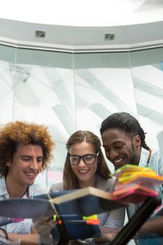 Creative young business people looking at digital tablet at office desk