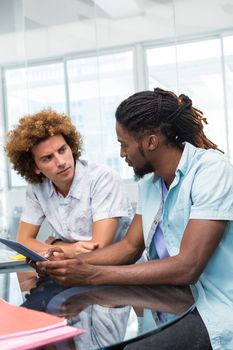 Creative young business people with digital tablet at office desk