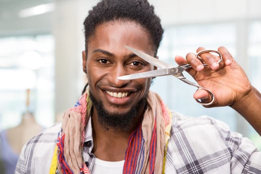 Portrait of happy male fashion designer holding scissors