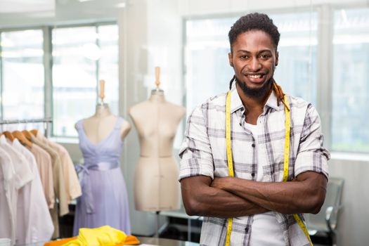 Portrait of confident male fashion designer standing with arms crossed