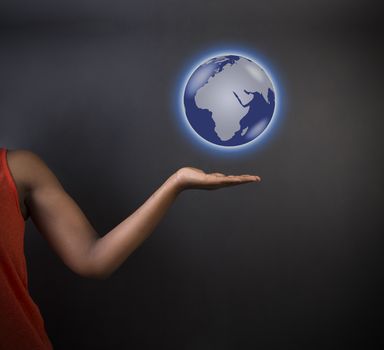 South African or African American woman teacher or student holding world earth globe in the palm of her had on black background