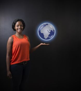 South African or African American woman teacher or student holding world earth globe in the palm of her had on black background