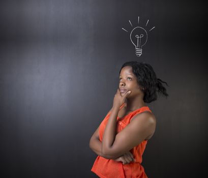Bright idea chalk background lightbulb thinking South African or African American woman teacher or student