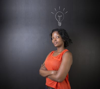 Bright idea chalk background lightbulb thinking South African or African American woman teacher or student