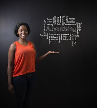 South African or African American woman teacher or student against blackboard background with chalk advertising diagram