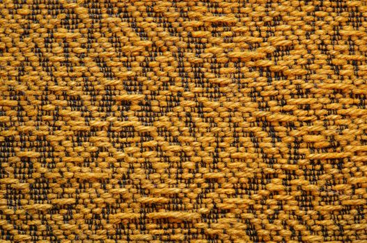 Woolen upholstery with orange color with a pattern of black thread as abstract background
