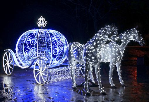 Decorative carriage with horses decorated with lights                              