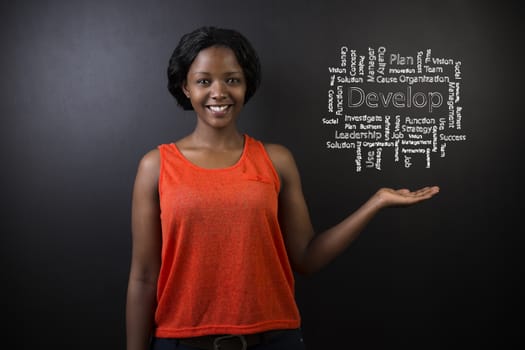 South African or African American woman teacher or student standing with her hand out against a blackboard background with a chalk develop diagram