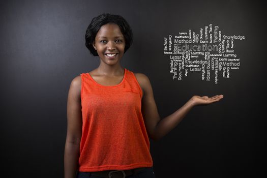 South African or African American woman teacher or student holding her hand out against a blackboard background with a chalk education diagram