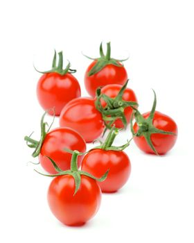 Arrangement of Shiny Ripe Cherry Tomatoes with Stems isolated on white background. Focus on Foreground