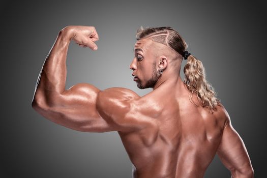Attractive male body builder on gray background