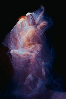 photo as art - a sensual and emotional dance of  the one beautiful ballerina through the veil on a dark background