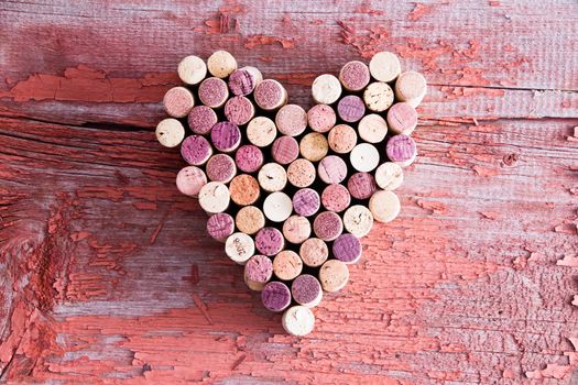 Plenty of Wine Bottle Corks Formed in Heart Shape for Love Concept on Top of an Old Wooden Table in High Angle View.