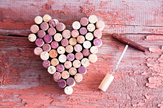 Close up Corks in Heart Shape and Wine Bottle Opener on Top of a Rustic Wooden Table for Love Concept. Captured in High Angle View.