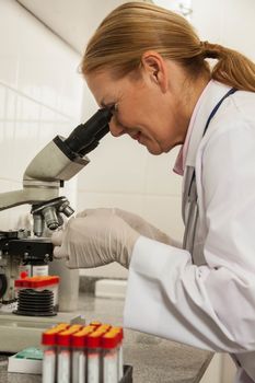 woman looking from the microscope