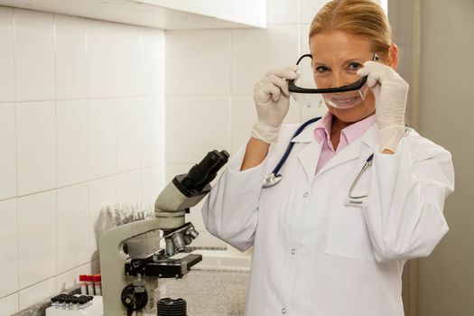 woman putting her glasses at the lab