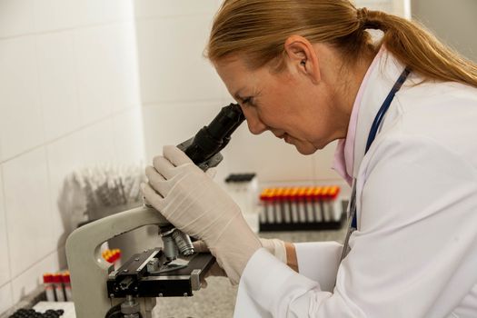 woman looking from the microscope