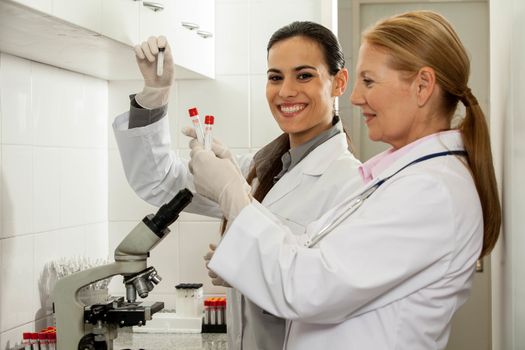 young women smiling and old women serious in the lab