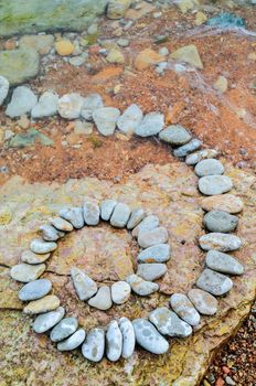 Spiral of pebbles on the textured boulder