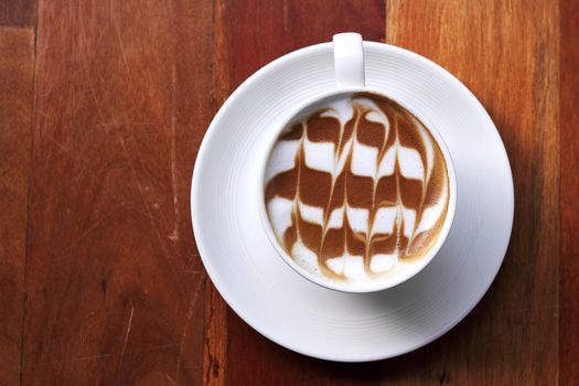 Cup of latte coffee on the wooden desk