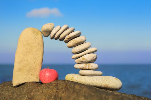 Arch of pebbles and apple between of the stones on the coast