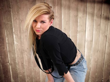 blonde girl in jeans against wooden background