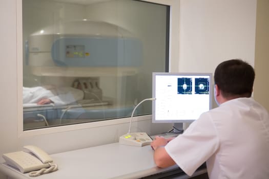 doctor analyzing results of woman patient at bone densitometer machine.