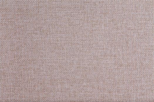 Background texture of coarse woven beige fabric with an open mesh weave of natural fibers in a full frame view