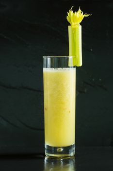 Glass of celery juice on black background