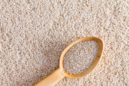 High Angle Full Frame View of Sesame Seeds Background with Wooden Spoon Scoopful