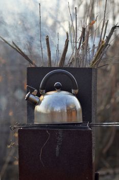 the whistling kettle begins to boil on a brazier