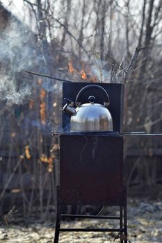 the whistling kettle begins to boil on a brazier.