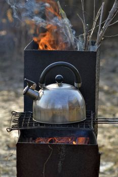 the whistling kettle begins to boil on a brazier