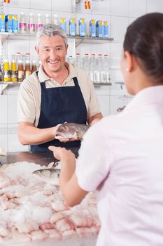 Man giving a white salmon to a costomer