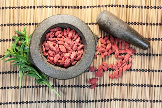 Dry goji berries in a stone mortar.