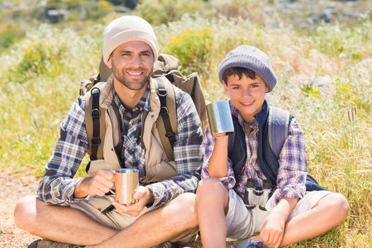 Father and son hiking in the mountains on a sunny day