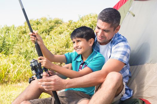 Father and son beside their tent on a sunny day