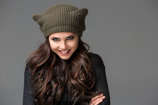 Beautiful sexy young woman in a  funny hat with ears smiling on gray background