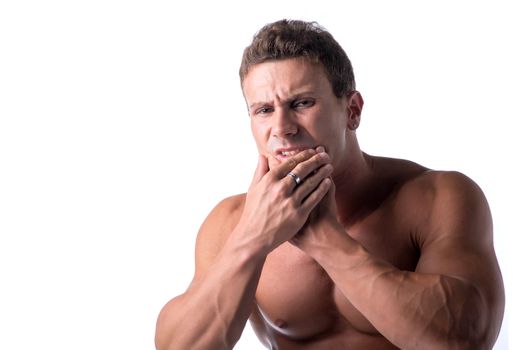 Muscular handsome man holding his jaw with one hand and grimacing in pain for toothache, isolated on white