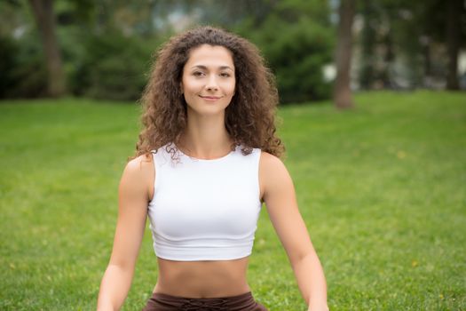 Pretty sports woman in outdoor park, green grass background 